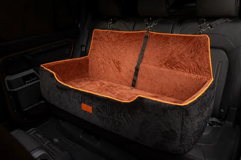 Assento G preto e marrom instalado no Defender mostrando detalhe do acabamento laranja